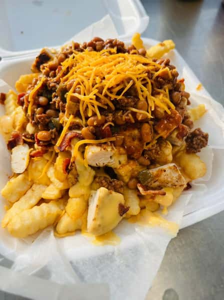Loaded crinkle-cut fries topped with grilled chicken, hearty chili, melted cheddar cheese, and diced peppers in a takeout container, showcasing indulgent Southern comfort food and casual diner fare.Loaded crinkle-cut fries topped with grilled chicken, hearty chili, melted cheddar cheese, and diced peppers in a takeout container, showcasing indulgent Southern comfort food and casual diner fare.
