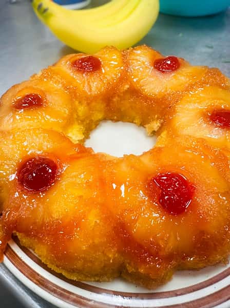 Pineapple upside-down bundt cake with caramelized pineapple rings and maraschino cherries, glazed to perfection as a classic Southern dessert.