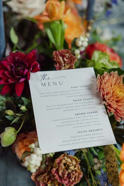 Printed event menu surrounded by flowers