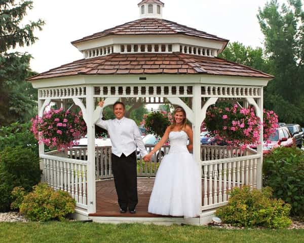 bridge and groom posing for a picture in gazebo