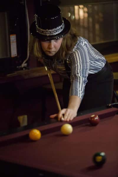 lady dressed in 1920s era clothes playing pool