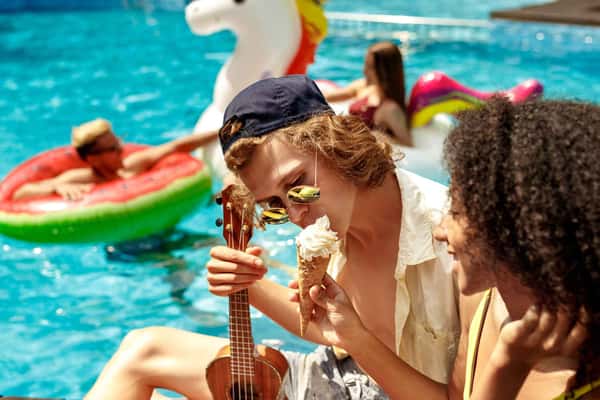 a man holding a ukulele and eating an ice cream