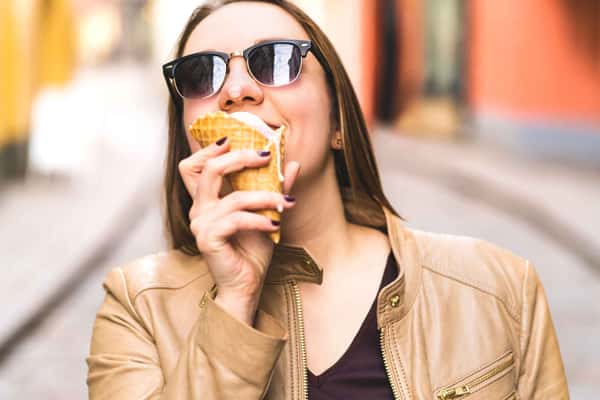 woman wearing sunglasses and eating ice cream