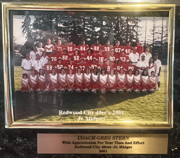 Framed team photo of the Redwood City 49ers Jr. Midgets 2001, showing youth football players, cheerleaders, and coaches on a field.