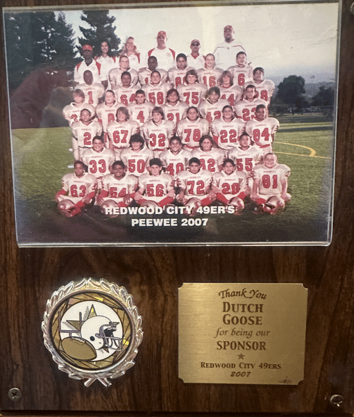 Framed youth football team photo reading "Redwood City 49ers Peewee 2007," with sponsor plaque thanking Dutch Goose.