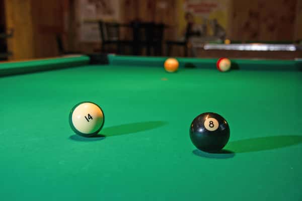 Pool table with billiard balls in a casual game area at Blackwell Revival in Atkins, Arkansas, highlighting a relaxed dining atmosphere