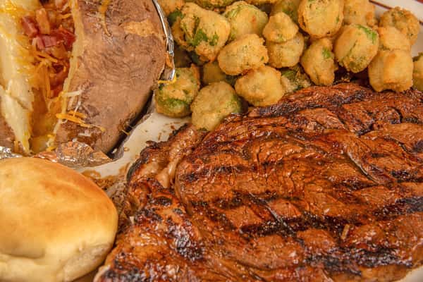 Close-up of grilled ribeye steak with charred seasoning and juicy texture at Blackwell Revival in Atkins, AR