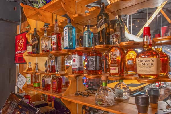 Shelves of whiskey and liquor bottles behind the bar at Blackwell Revival in Atkins, AR, emphasizing a full-service bar experience