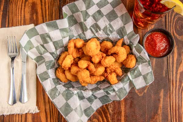 Top view of crispy fried shrimp basket with cocktail sauce at Blackwell Revival in Atkins, AR, featuring Southern Cajun seafood
