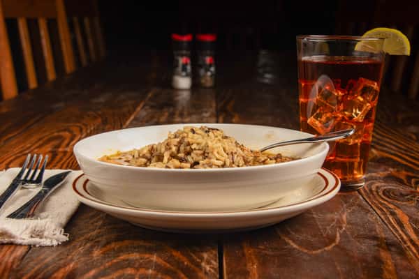 Bowl of Cajun gumbo served with rice and a drink at Blackwell Revival in Atkins, AR