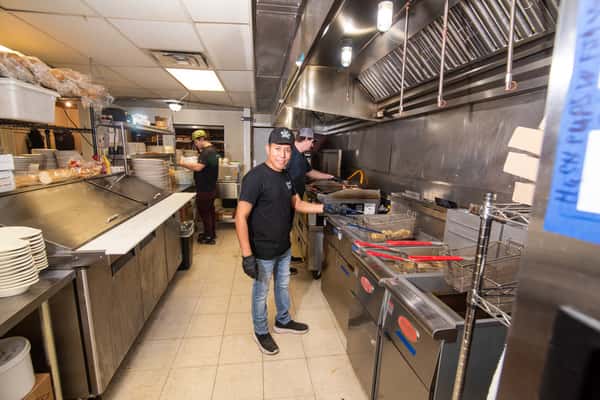 Open kitchen with staff preparing food at Blackwell Revival in Atkins, AR, emphasizing a casual and welcoming dining experience