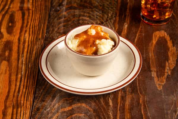 Creamy mashed potatoes topped with rich Cajun gravy at Blackwell Revival in Atkins, Arkansas, a classic Southern comfort side