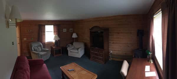 Living room with coffee table, tv in stand, lamps, lounge chair