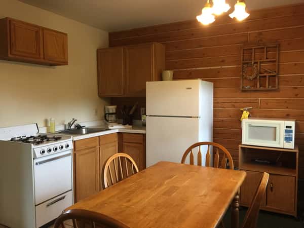 Kitchen with table and chairs, refrigerator, cabinets, stove