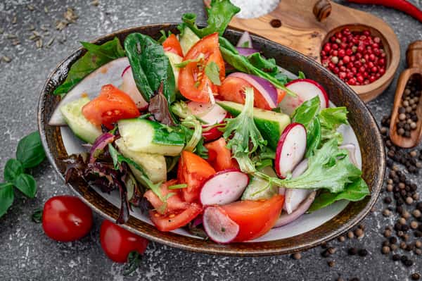 Fresh garden salad with cucumbers, tomatoes, and radishes