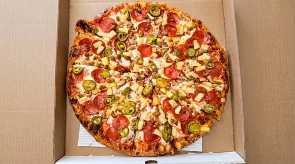 Whole pizza in a cardboard box topped with pepperoni, sausage, pineapple, and jalapeños.