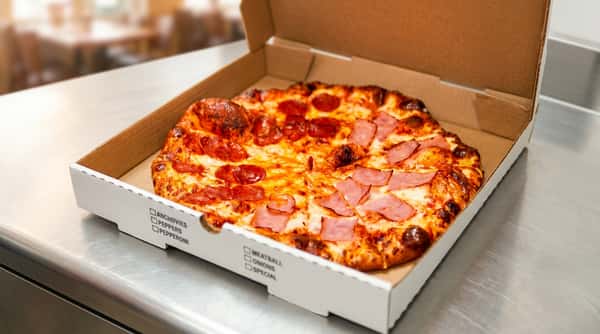 Half pepperoni, half ham pizza with melted cheese in an open cardboard box.