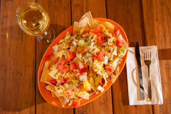 big bowl of tortilla chips covered in dip and sour cream