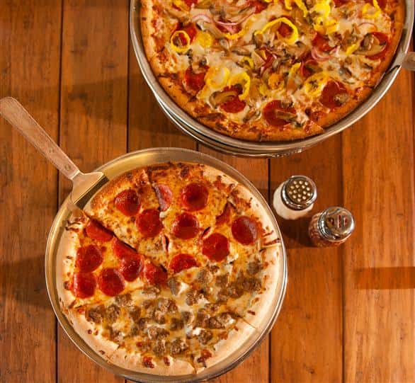 pepperoni and supreme pizzas with salt and pepper