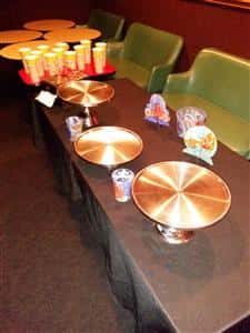 table with green chairs and round trays to hold pizzas