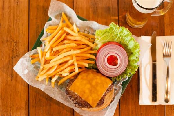 cheeseburger with lettuce and onions with a side of french fries