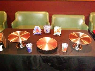 table with green chairs and round trays to hold pizzas