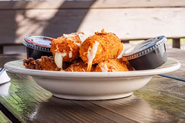 Golden fried mozzarella sticks with melted cheese oozing out, topped with Parmesan and served with marinara and ranch dipping sauces.