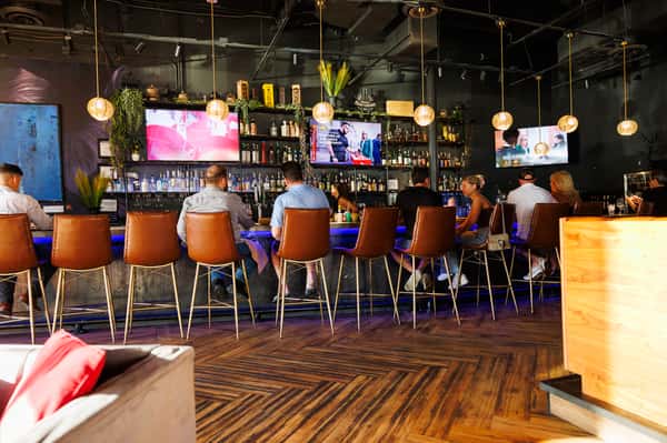 Modern sports lounge interior with bar seating, large-screen TVs, craft cocktails, and an energetic nightlife atmosphere in North Scottsdale.