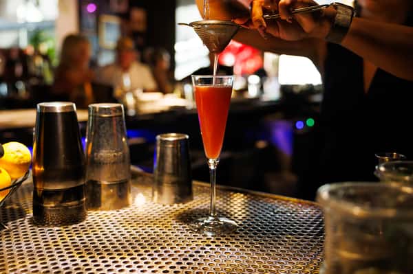 Handcrafted signature cocktail being prepared at the bar, showcasing EVO North Scottsdale's elevated craft drink experience.