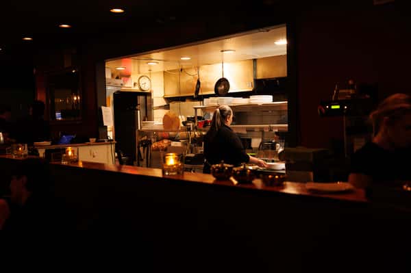 Open kitchen and chef's counter at EVO Old Town Scottsdale showcasing a modern dining atmosphere and culinary craftsmanship.