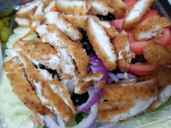 house salad with sliced breaded chicken on top