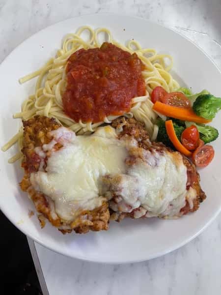 spaghetti and chicken parm with a side of vegetables