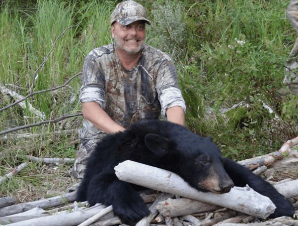 man posing for a photo with a bear