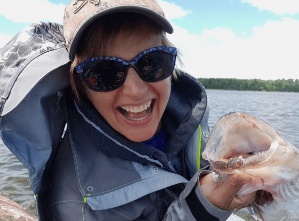 woman holding a fish posing for a photo