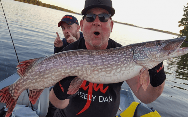 man holding a fish posing for a photo