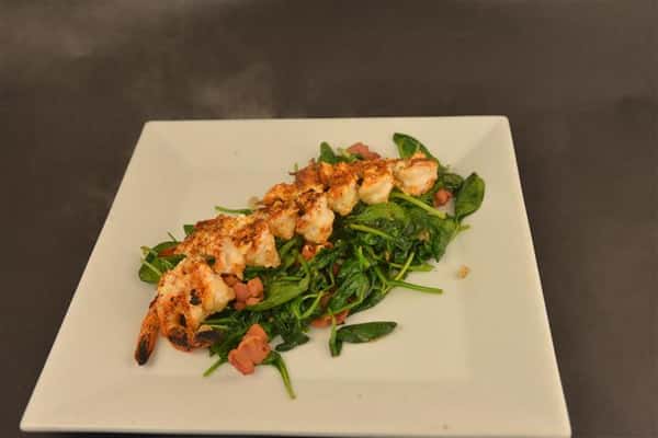 Shrimp topped on leafy greens