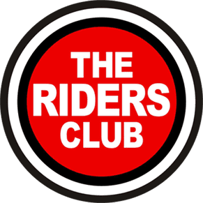 Logo for The Riders Club, featuring bold white text on a red circular background, outlined with black and white rings for a striking, retro-inspired look.