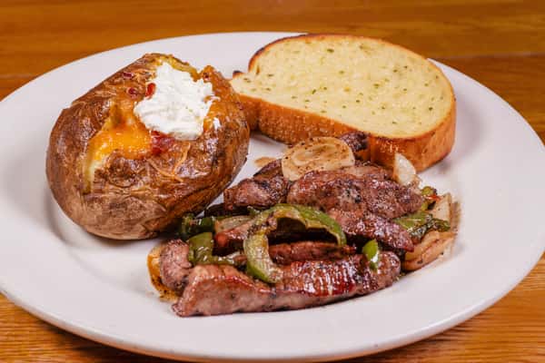 Beef tips with baked potato and toast at Jake & Rip's, a Southern barbecue restaurant in Grenada, MS.