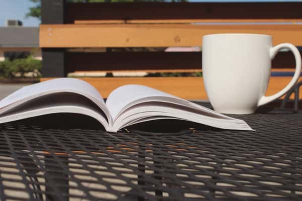 cup of coffee with a book on a table