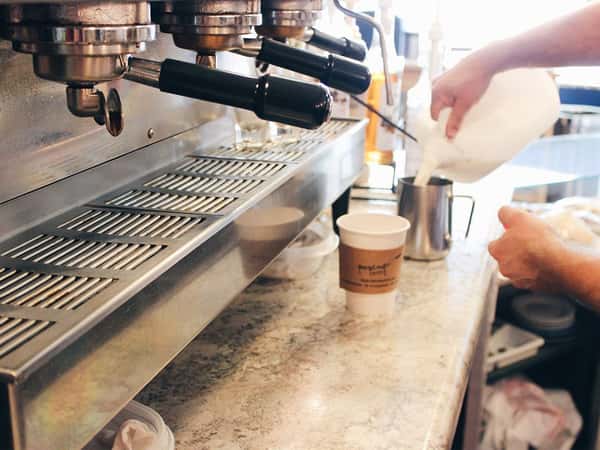 barista pouring milk in a cup