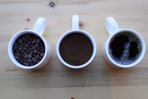 three mug lined up with liquid, coffe beans, and coffee powder