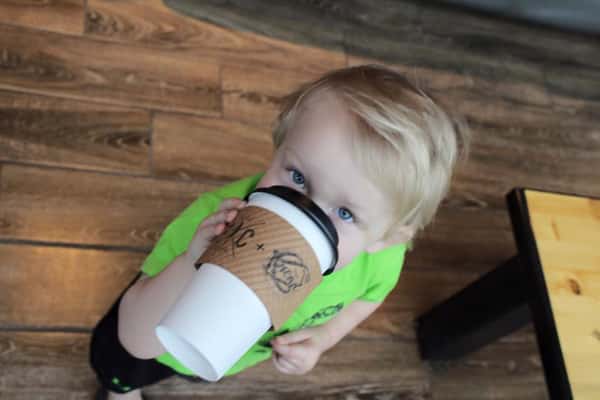 child drinking a cup of coffee