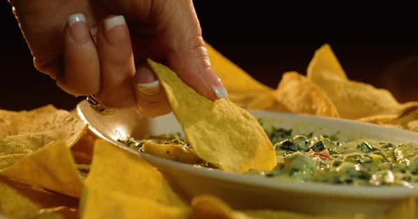 spinach and artichoke dip with chips to dip in it