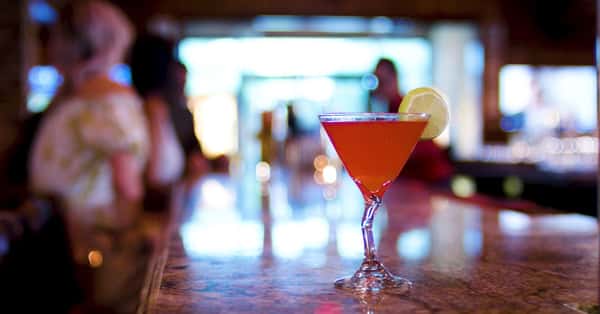 pink martini on the bar counter with a lemon garnish