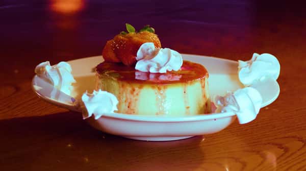 flan with strawberry garnish and whipped cream