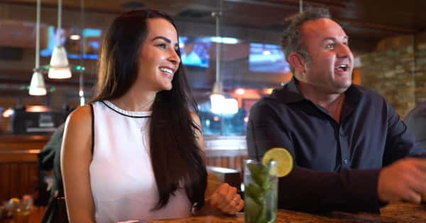 Woman at the bar with a man drinking a mojito
