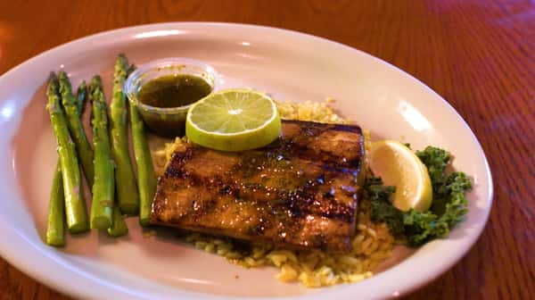 seasoned salmon on rice and a side of asparagus