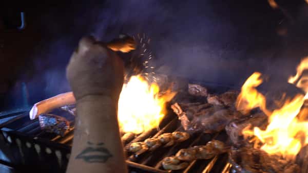 chef seasoning the meat on the grill