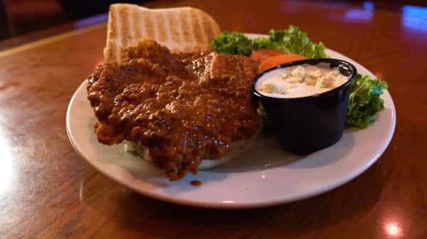 buffalo chicken sandwich on a bun with a side of bleu cheese