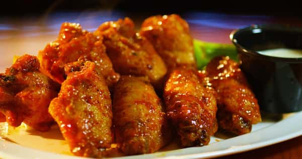 wings seasoned with hot sauce and a side of celery